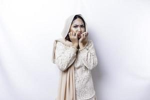 jovem ásia muçulmano mulher isolado em branco fundo, parece depressivo, face coberto de braços assustado e nervoso. foto