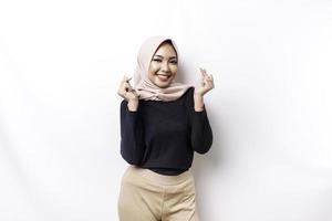 uma feliz jovem ásia mulher vestindo hijab sente romântico formas coração gesto expressa concurso sentimentos foto