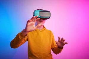 Garoto com virtual realidade óculos em colorida fundo. futuro tecnologia foto