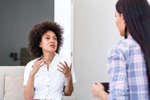 mulher na sessão de terapia. psicólogo atencioso. psicóloga atenta segurando lápis nas mãos fazendo anotações escritas enquanto ouve seu cliente foto