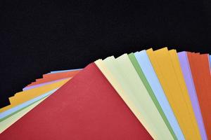 multicolorido folhas do papel em uma Preto fundo. colori escritório papel. uma pacote do colori papel. foto