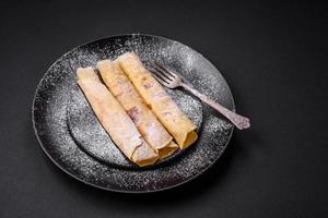 delicioso fresco cozido panquecas com querida e frutas em uma concreto fundo foto