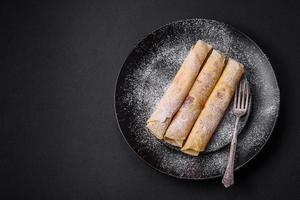 delicioso fresco cozido panquecas com querida e frutas em uma concreto fundo foto