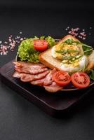 delicioso saudável almoço consistindo do bacon, brinde, ovos e tomates