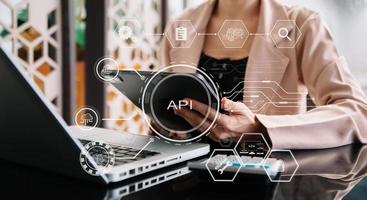 interface de programação de aplicativos api, mulher usando laptop, tablet e smartphone com ferramenta de desenvolvimento de software de ícone api de tela virtual, tecnologia e conceito de rede. foto