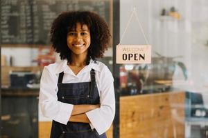 startup bem sucedido pequeno empresário sme beleza garota stand com smartphone tablet no restaurante café. retrato do proprietário do café barista mulher bronzeada asiática. conceito de negócio de vendedor de sme empreendedor foto