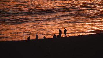 silhueta de uma família apreciando o pôr do sol foto