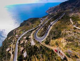 aéreo tiro do carros passagem através uma espiral estrada cercado de árvores dentro a campo foto