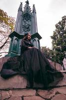 a ásia mulher vestido todos dentro Preto estava sentado dentro uma cemitério com uma muito assustador expressão enquanto atendendo a morte do dela irmão foto