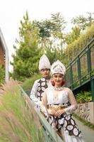 uma casal dentro branco roupas posando muito intimamente e intimamente dentro uma parque foto