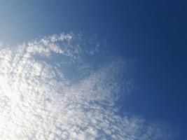 lindas nuvens brancas sobre fundo de céu azul profundo. grandes nuvens fofas e brilhantes cobrem todo o céu azul. foto