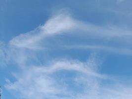 lindas nuvens brancas sobre fundo de céu azul profundo. grandes nuvens fofas e brilhantes cobrem todo o céu azul. foto