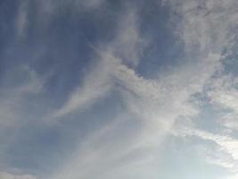 lindas nuvens brancas sobre fundo de céu azul profundo. grandes nuvens fofas e brilhantes cobrem todo o céu azul. foto