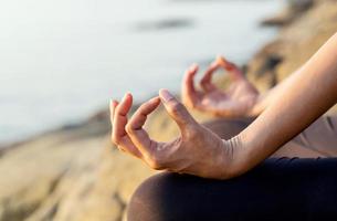close-up das mãos de uma mulher em meditação foto