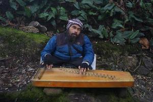 uma homem jogando kecapi tradicional sundanês música dentro a cidadã, bandung, oeste Java, Indonésia. foto