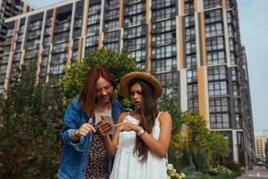 dois turistas felizes com um telefone em uma rua da cidade foto