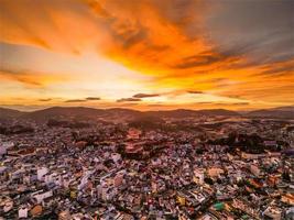 radiante pôr do sol Horizonte cativante vermelho céu Visão do da lat cidade, Vietnã com uma deslumbrante mistura do cores entre paisagem urbana e céu às crepúsculo foto