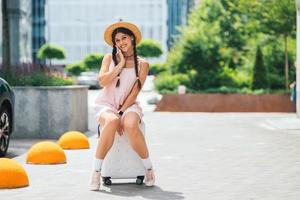 jovem e bela mulher caucasiana está sentada na maleta foto