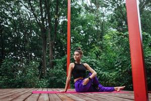 mulher fitness sentada no tapete fazendo ioga foto