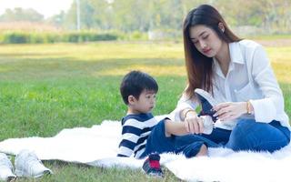 mãe asiática e filho felizes no parque foto