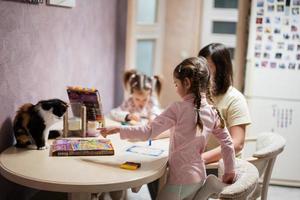 mãe e filhas decoração arte com brilhar decoração. Além disso gato com eles em mesa. foto