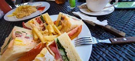 ocidental esteio café da manhã cardápio, carne sanduíches com legumes combinado com francês fritas foto