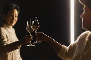 feliz sorridente mulher mão clicando óculos do vinho celebração conceito. foto