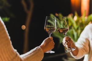 mulher mão clicando óculos do vinho celebração conceito. foto