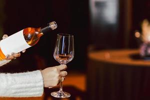 mulher mão segurando garrafa do rosa vinho e vinho vidro estilo de vida conceito. foto