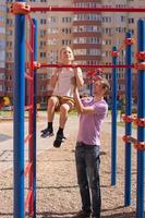 fofa bebê e Papai jogar em a Parque infantil foto