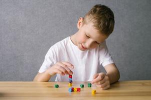 uma Garoto é jogando com colorida jogando cubos, construção uma torre foto