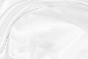fundo de pano texturizado de seda branca, closeup de tecido de cetim ondulado com ondas suaves. foto