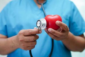 médico de mulher asiática segurando coração vermelho para saúde no hospital. foto