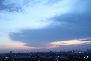 Sombrio azul nuvem com branco luz pôr do sol céu fundo e cidade luz meia noite tarde Tempo foto