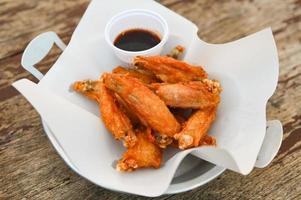 frito frango asas com molho tailandês Comida em de madeira mesa Comida fundo foto