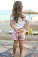 lindo pequeno menina em a de praia foto