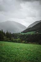 majestoso montanhas dentro a Alpes coberto com árvores e nuvens foto