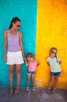 mãe e filhas em uma colorida parede foto