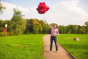 homem segurando coração em forma balões foto