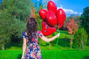 mulher segurando coração em forma balões foto