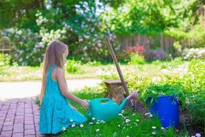 pequeno menina com flores dentro a jardim foto