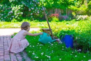 pequeno menina com flores dentro a jardim foto