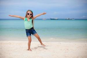 pequeno menina tendo Diversão em a de praia foto