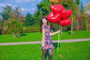 jovem mulher com vermelho coração balões foto