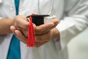 estudo de médico asiático aprende com chapéu de graduação na enfermaria do hospital, conceito de medicina de educação de gênio brilhante inteligente. foto