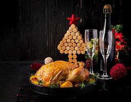 peru ou frango assado. a mesa de natal é servida com um peru decorado com enfeites brilhantes. frango frito, mesa. ceia de Natal. foto