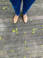 mulheres pernas dentro uma simples Castanho sapato. topo Visão do mulher perna vestindo sapatos e magro azul jeans. simples e rua moda. foto