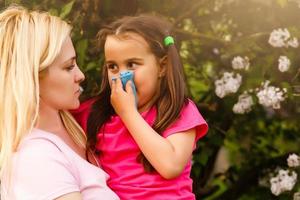 alergia. mãe e bebê sopro nariz ao ar livre foto