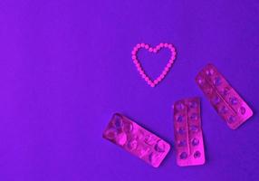coração símbolo fez a partir de pílulas e comprimidos bolha em uma azul fundo com cópia de espaço. contracepção e mulheres saúde conceito. criativo idéia para conectados farmacia e farmacêutico companhia negócios. foto