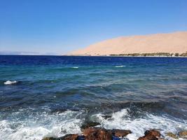 a hipnotizante Visão do a profundo azul águas do haql de praia dentro saudita arábia. foto